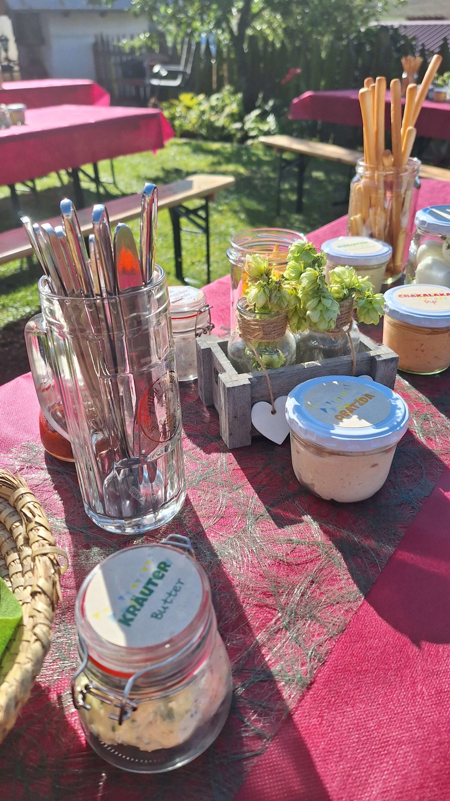 gedeckter herbstlicher Tisch mit Gläsern und Knuspersachen im Garten