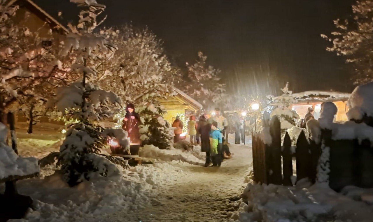 Winterweihnachten dunkel Schneebedeckter Garten, im Hintergrund ein Backofen mit Krippenfiguren