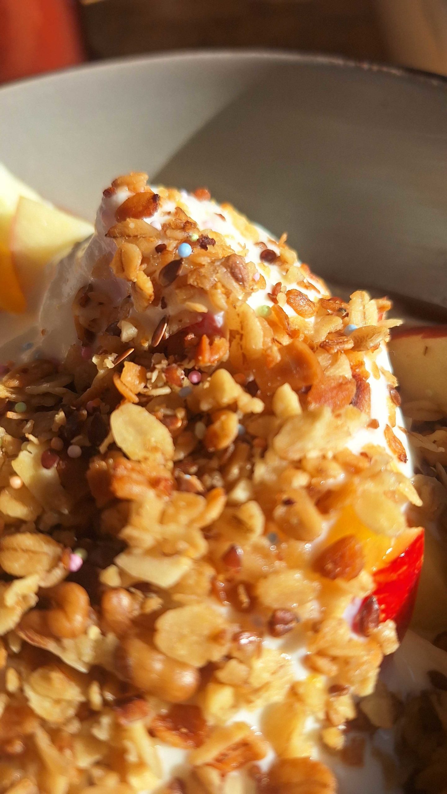 Obstsalat mit Joghurt und gebackenem Müsli mit bunten Zuckerperlen
